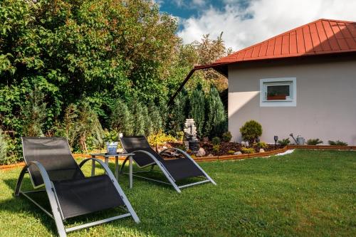 three chairs and a table in a yard at Sherwood Hotel Vojkovice nad Ohří in Vojkovice