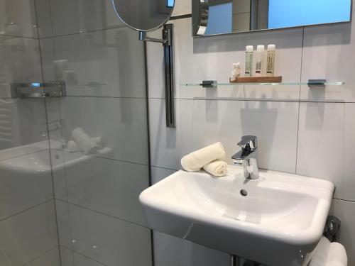 a white bathroom with a sink and a shower at Ferienhaus An der Hilb in Stetten am Kalten Markt