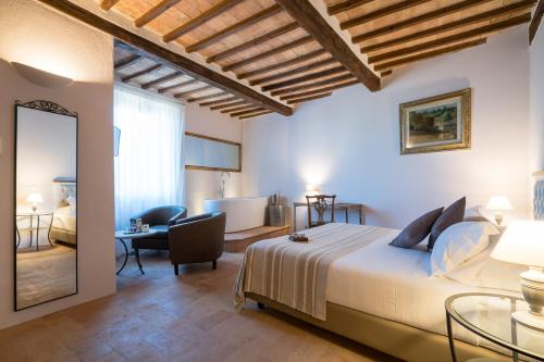 a bedroom with a king sized bed and a mirror at Dimora delle Muse in Montalcino