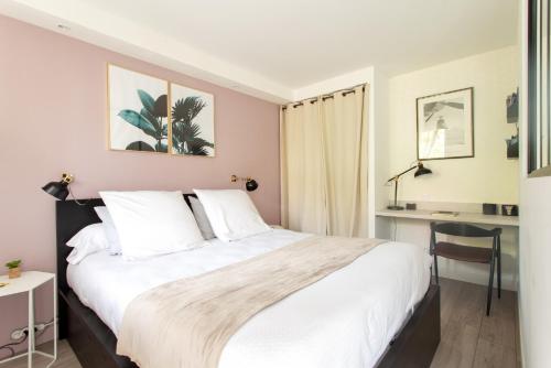 a bedroom with a large bed and a desk at Studio climatisé Le Marilyn - Dormiratoulouse Blagnac in Blagnac