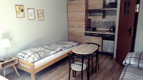 een kleine slaapkamer met een bed en een kleine keuken bij Pokoje u Anastazji in Zakrzewo