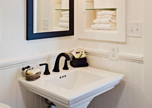 - Baño con lavabo blanco y toallas en Eldorado Suites Hotel en Bisbee