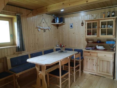 a kitchen with a wooden table and blue chairs at Brunarica na Goreljeku in Bohinj