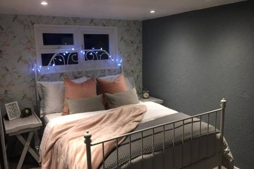 ein Schlafzimmer mit einem Bett mit Beleuchtung in der Unterkunft Mudeford Mews in Mudeford