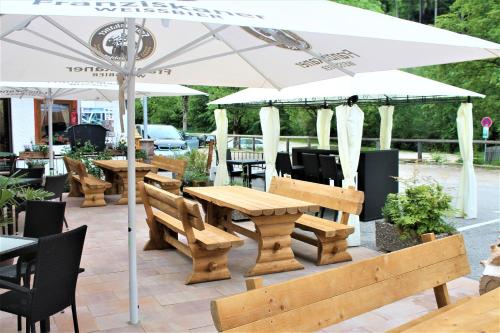 a wooden table and benches under an umbrella at Gasthof Wimbachklamm in Ramsau