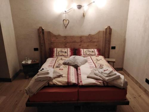 a bedroom with a bed with a wooden headboard at A la Ciasa de l'Artista in Cibiana