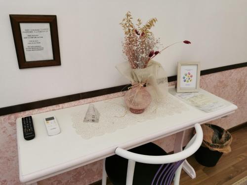 a white table with a vase of flowers on it at Bed and Breakfast al Cucherle in Trieste