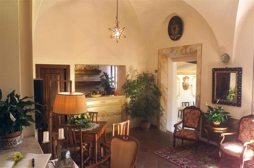 uma sala de estar com mesa e cadeiras em Hotel Santa Caterina em Siena