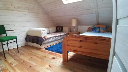Habitación con cama y sofá en una habitación en Agroturystyka Helena, en Okuninka