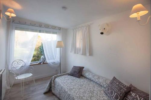 een slaapkamer met een bed en een raam bij Couette & Confitures in Nojeon-le-Sec