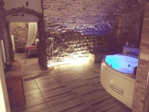 La grotta dell'Antica Calvasino - Jacuzzi في ليتْسّينو: حمام مع حوض استحمام ومغسلة