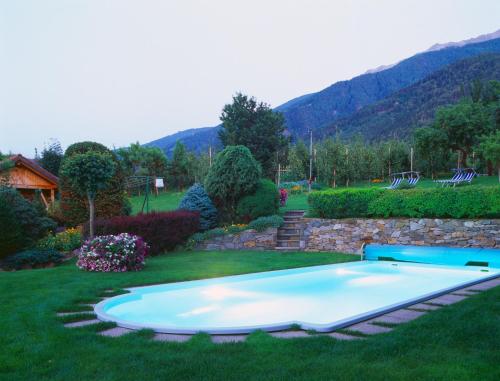 a swimming pool in the middle of a yard at Gasthof Weisses Kreuz in Naturno