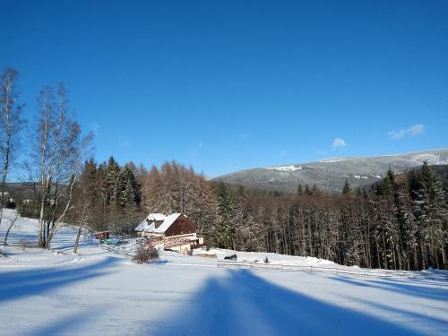 a house in the middle of a snow covered field at Chalupa Barborka - Národní park Krkonoše, sauna, bazén, dětské hřiště, gril, 6 pokojů, kuchyň, společenská místnost s krbem in Vrchlabí