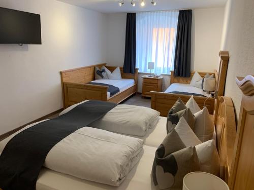 a hotel room with two beds and a flat screen tv at Gasthof zum Waldstein in Zell im Fichtelgebirge