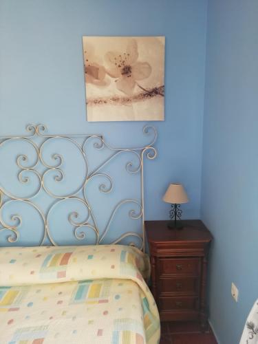 a blue bedroom with a bed and a nightstand at Casa Cabo de Gata in Retamar