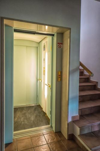 a hallway with a stairway with a door and a stair case at Pension Fellis in Vols am Schlern