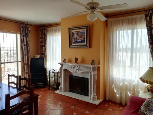 a living room with a fireplace and a ceiling fan at Casa Cabo de Gata in Retamar