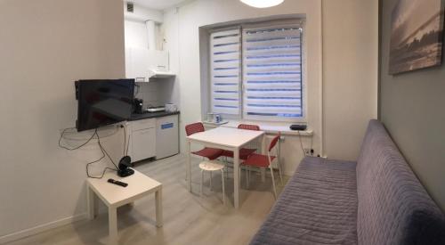 um pequeno quarto com uma mesa e uma cama e uma cozinha em Chopin apartments self check-in em Varsóvia