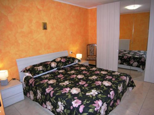 een slaapkamer met een bed met een bloemdekbed bij Casa Mary in San Siro