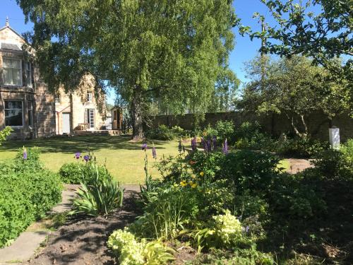 a garden with flowers in front of a house at Kilmorie House in Elgin