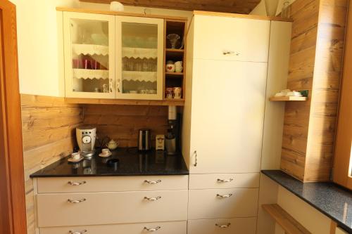 a kitchen with white cabinets and black counter tops at Chalet Damtschach in Damtschach