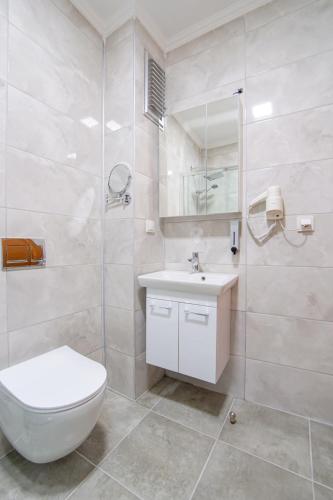 a white bathroom with a toilet and a sink at Ova Butik Otel in Mesudiye