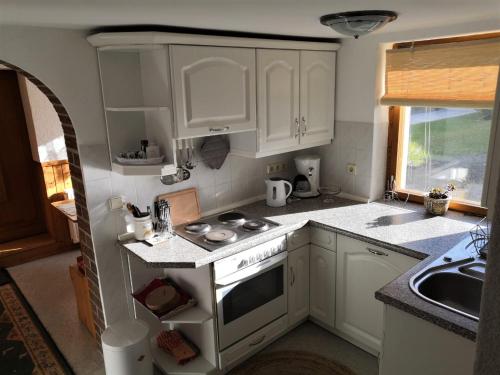 a kitchen with white cabinets and a stove top oven at Sonnenblume in Heidesee