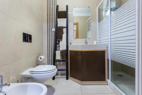 ein Badezimmer mit Toilette, Waschbecken und Dusche in der Unterkunft Apartamento sobre a praia in Olhos de Água