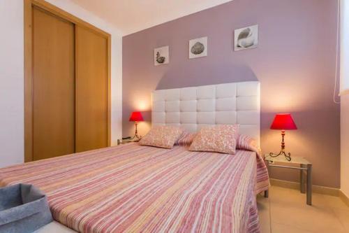 ein Schlafzimmer mit einem großen Bett mit zwei Lampen in der Unterkunft Apartamento sobre a praia in Olhos de Água