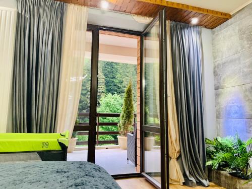 a bedroom with a bed and a large glass door at Maya Luxury Residence in Poiana Brasov