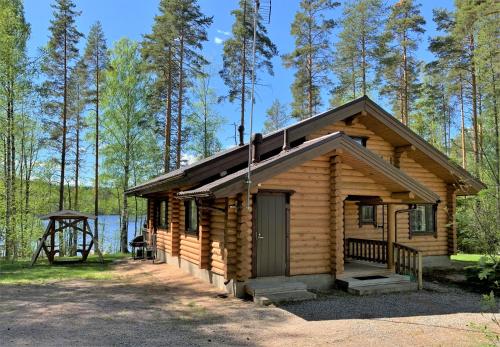 een blokhut in het bos naast een meer bij Lappalaisen lomamökit Norpparanta in Puumala