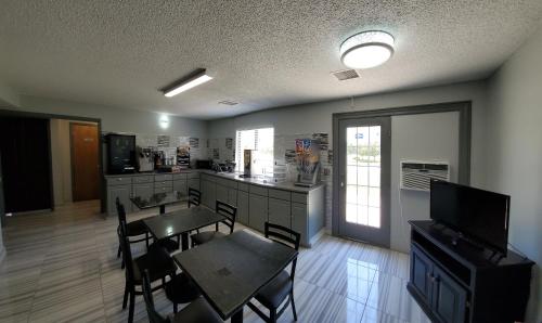 a kitchen with a table and a table and chairs at Super 8 by Wyndham Kansas City Airport North in Kansas City