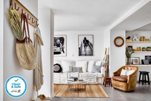 a living room with a white couch and a chair at Bem Lembrados Apartment in Cascais