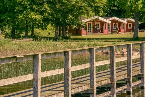 a wooden bridge over a pond with a house in the background at Danhostel Skanderborg in Skanderborg