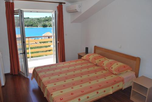 a bedroom with a bed and a large window at Apartmani Ivan in Kaprije