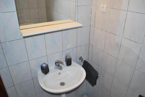 a white bathroom with a sink and a mirror at Apartmani Ivan in Kaprije