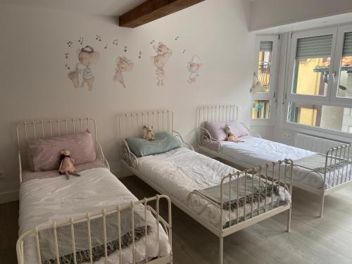 duas camas com ursinhos de peluche num quarto em Itsasoan Barrena em Lekeitio