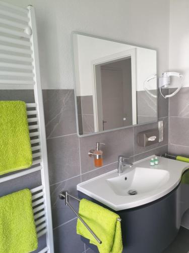 een badkamer met een wastafel en een spiegel bij Ferienwohnung Leilas Lodge in Langelsheim