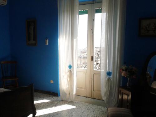 Habitación azul con puerta y ventana en Casamuseo del Risorgimento en Lungro
