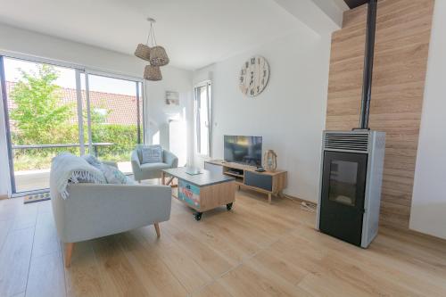 a living room with a couch and a tv at Villa Bellevue in Ambleteuse