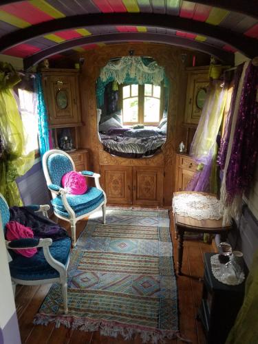 una stanza con due sedie e un letto in una stanza di La roulotte de Glorit a Bourg-sur-Gironde