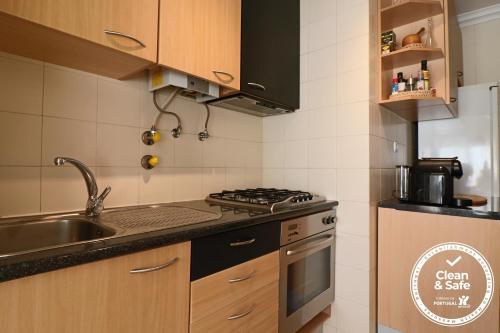 a kitchen with a sink and a stove top oven at Cascais Estoril Apartment 400 m from Beach in Estoril