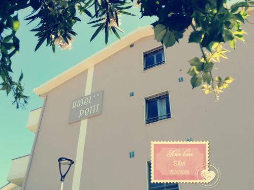 ein weißes Gebäude mit einem Schild davor in der Unterkunft Hotel Petit in Silvi Marina