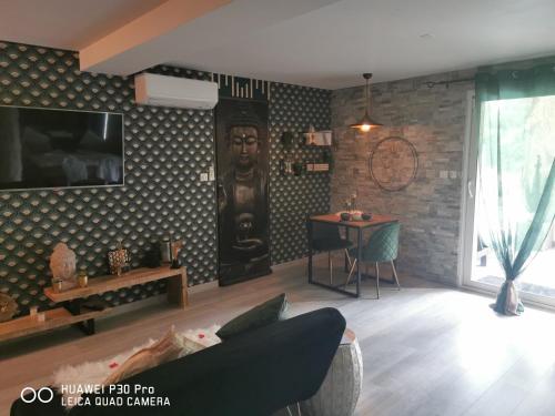 a living room with a statue on the wall at Suite romantique Le temps d'un Instant Loveroom Hammam jacuzzi piscine in Villeneuve