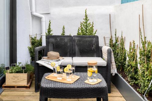 a patio table with glasses and a hat on it at Bem Lembrados Apartment in Cascais