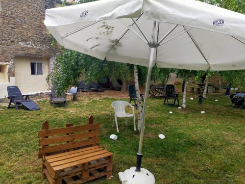 a white umbrella and a bench in a yard at ALBERGUE CASA BAZTAN in Uterga