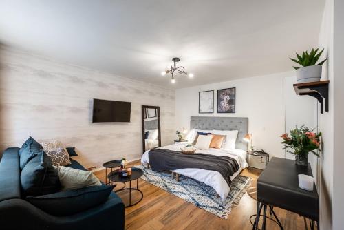 a bedroom with a bed and a couch and a tv at Penzion Mácha in Litoměřice
