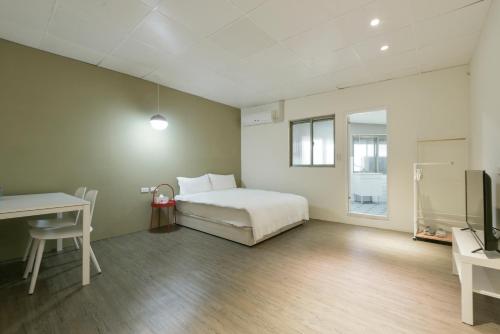 a bedroom with a bed and a desk and a tv at 逢甲All Night龍 in Taichung