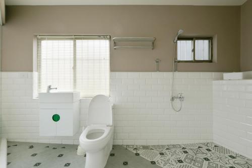 a white bathroom with a toilet and a shower at 逢甲All Night龍 in Taichung