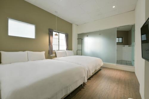two white beds in a room with a shower at 逢甲All Night龍 in Taichung